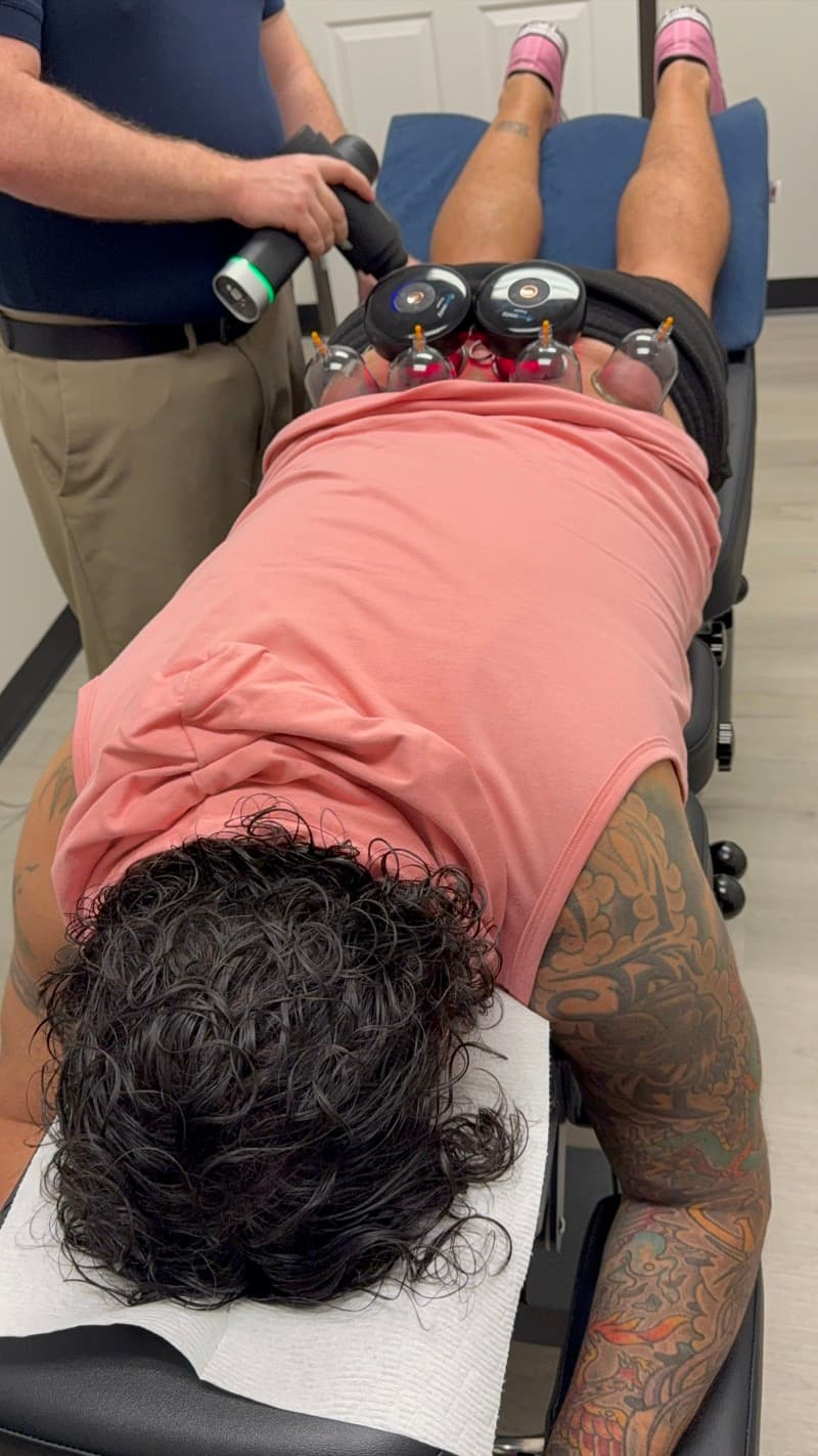 Dr. Smith performing percussion and cupping therapy on a patient at Tailored Touch LV in Henderson, NV