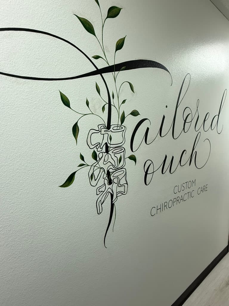 Hand-painted Tailored Touch Custom Chiropractic Care wall mural with a vine growing along a line-drawn spine